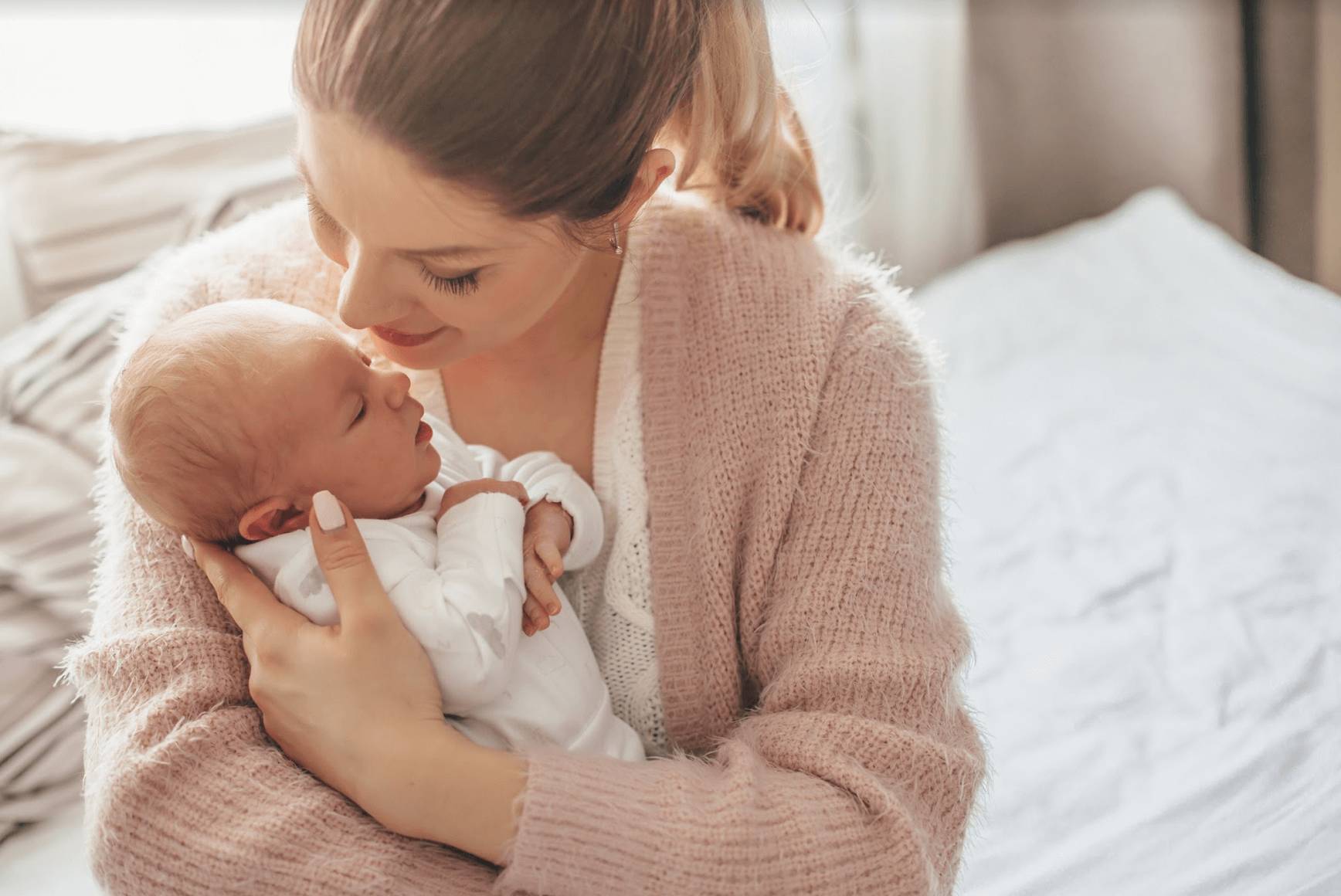 A photo of a mother holding her young newborn baby